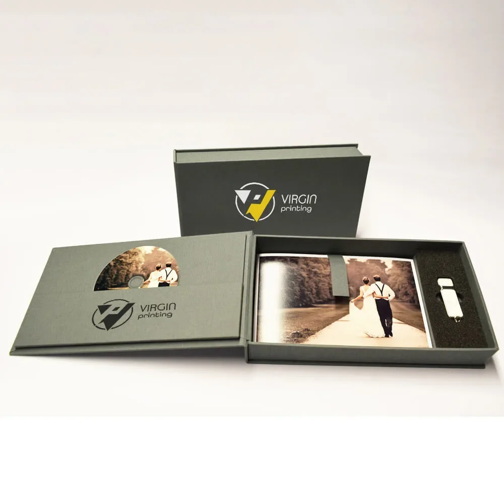 Cajas r&iacute;gidas verdes con impresi&oacute;n personalizada, abiertas y cerradas, que contienen un libro de fotos impreso y una unidad USB en un inserto de espuma, con fotos impresas y un logotipo a dos colores en las tapas.